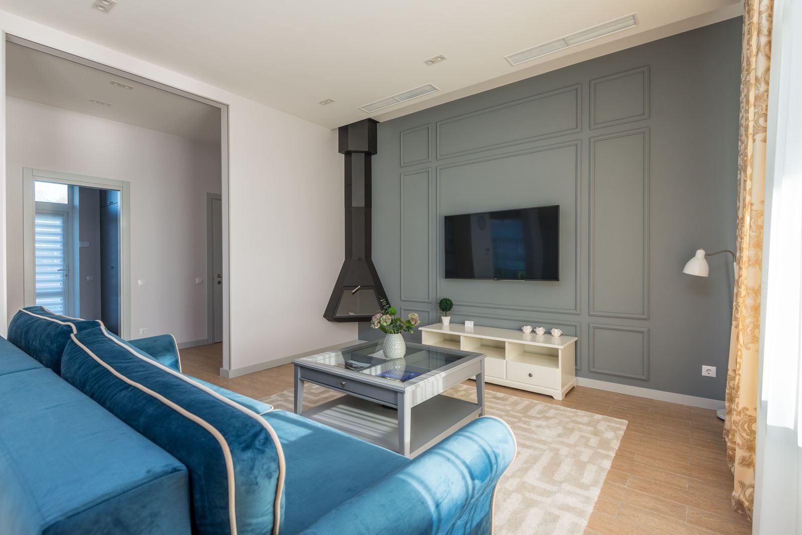 A living room featuring a couch and wall-mounted TV