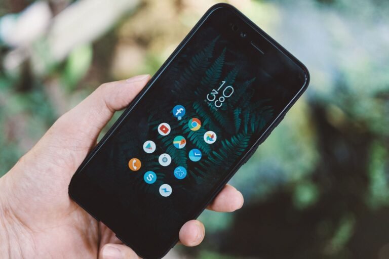 Close-up of a hand holding a smartphone with app icons